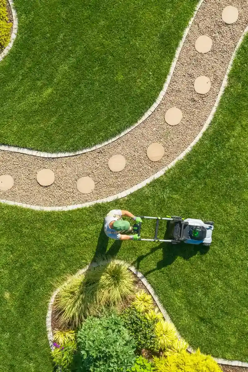Vue aérienne d'un jardinier tondant la pelouse